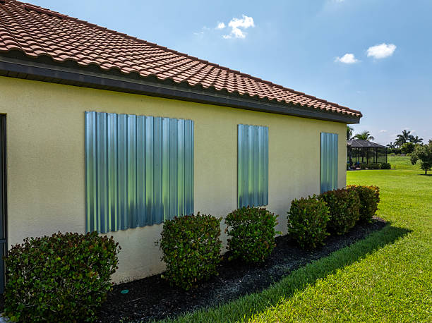 Florida house with hurricane shutters closed over the windows ahead of a tropical storm.
